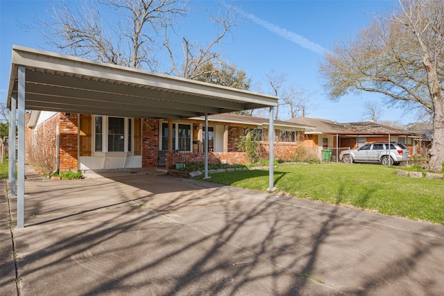 view of front of house with a carport, driveway, brick siding, and a front yard