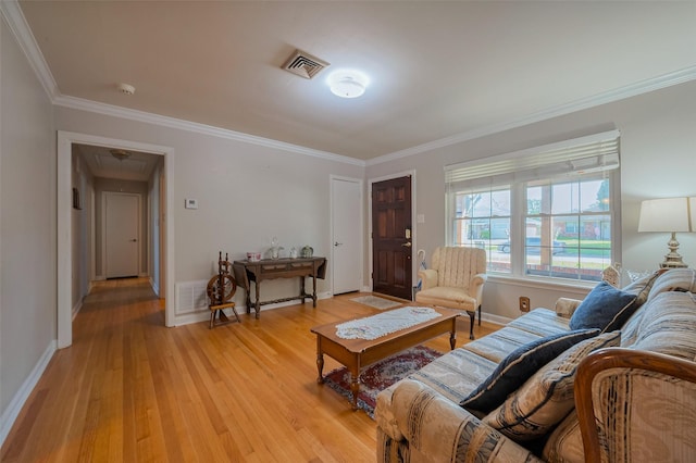 living room with light wood-style flooring, baseboards, visible vents, and ornamental molding