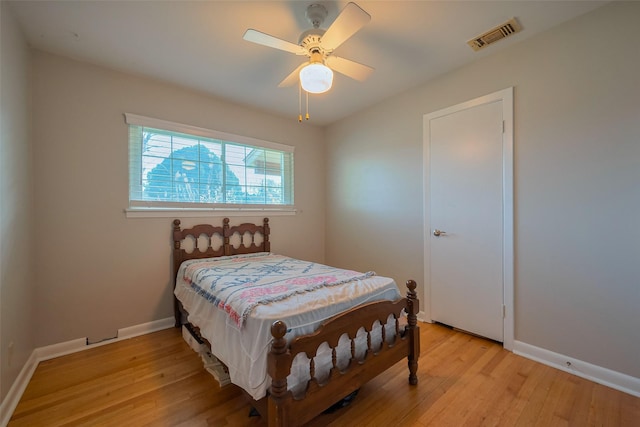 bedroom with a ceiling fan, baseboards, visible vents, and light wood finished floors