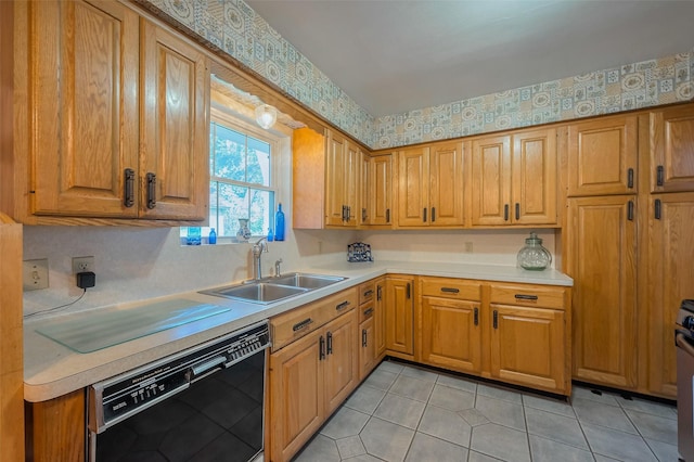 kitchen with wallpapered walls, light countertops, black dishwasher, brown cabinets, and a sink