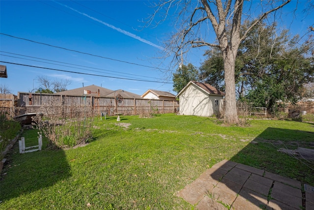 view of yard featuring a fenced backyard, an outbuilding, and a storage shed