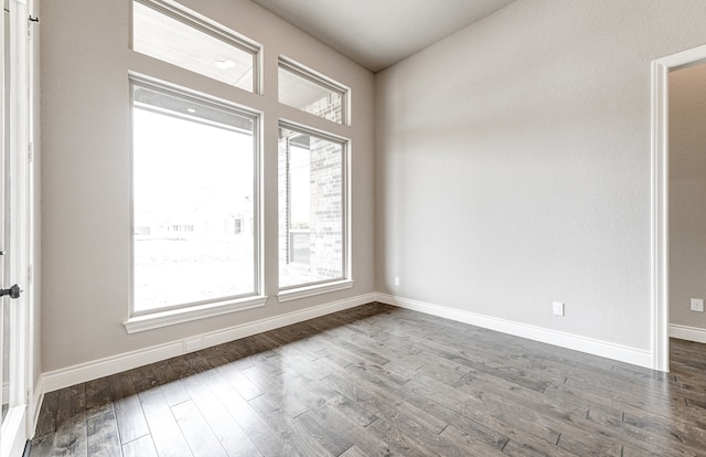 unfurnished room with dark wood-style floors and baseboards