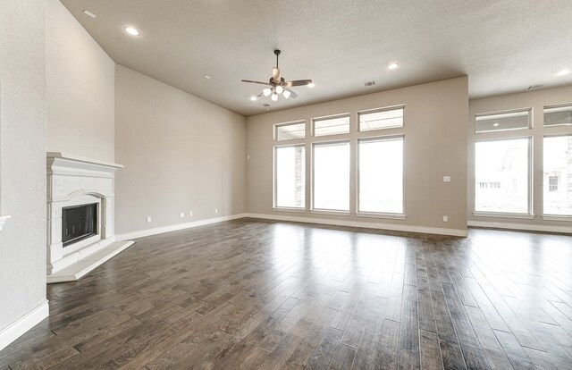 unfurnished living room with a high end fireplace, dark wood-type flooring, and baseboards