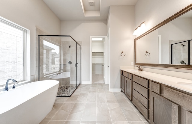 full bath with double vanity, a freestanding tub, visible vents, and a stall shower