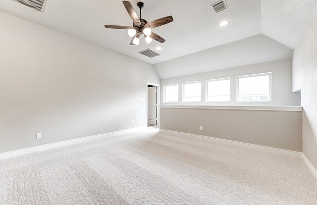 empty room with visible vents, baseboards, and lofted ceiling