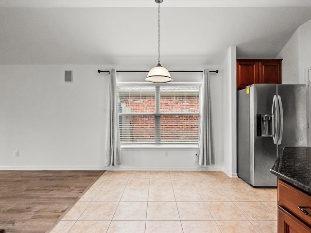 unfurnished dining area featuring light tile patterned flooring, visible vents, and baseboards