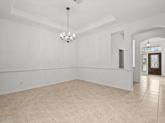 spare room with a tray ceiling, arched walkways, an inviting chandelier, light tile patterned floors, and baseboards