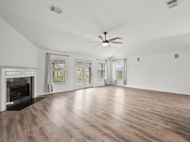 unfurnished living room featuring visible vents, lofted ceiling, ceiling fan, and a fireplace