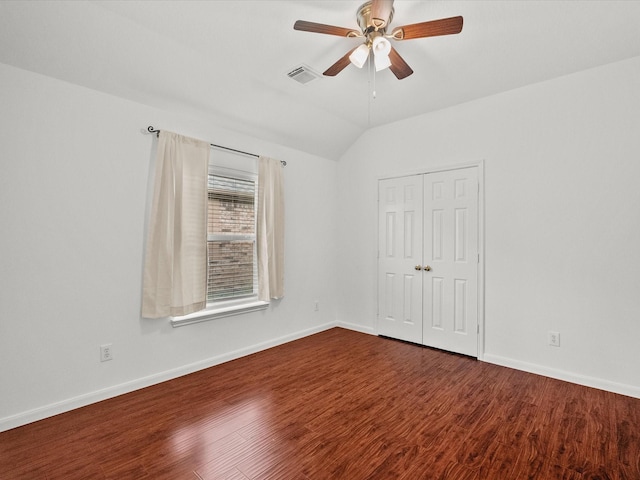 spare room with visible vents, ceiling fan, baseboards, dark wood finished floors, and vaulted ceiling