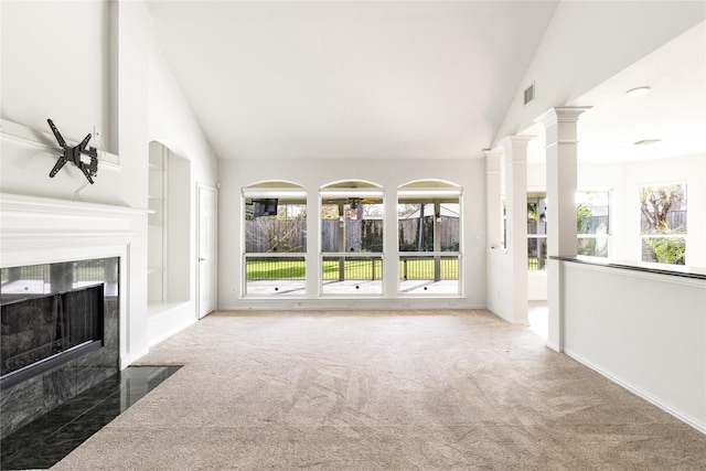 unfurnished living room with visible vents, a fireplace, ornate columns, and vaulted ceiling