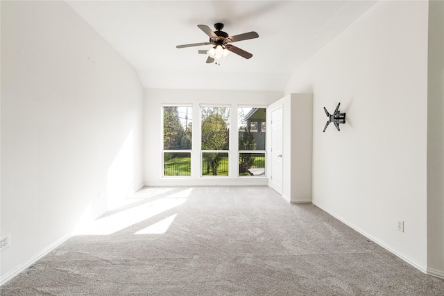 spare room with lofted ceiling, carpet, baseboards, and ceiling fan