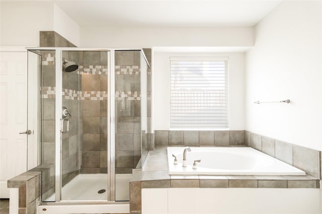 bathroom with a shower stall and a garden tub