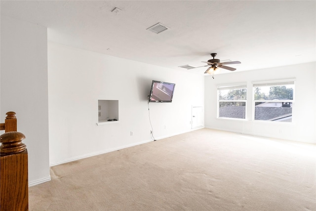 spare room with baseboards, light colored carpet, visible vents, and ceiling fan