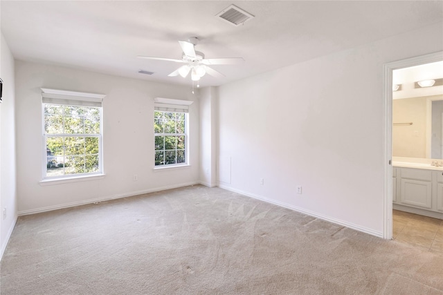 empty room featuring light colored carpet, visible vents, and baseboards