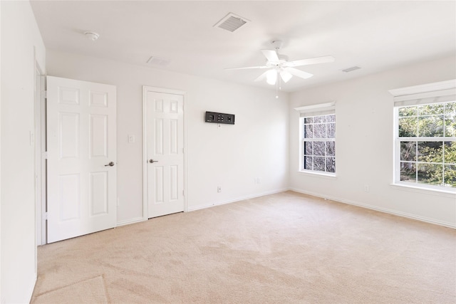 unfurnished bedroom with visible vents, light carpet, baseboards, and ceiling fan