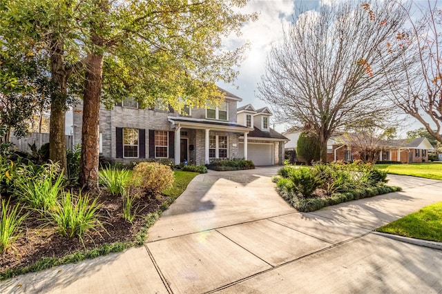 view of front of property with brick siding, stone siding, concrete driveway, and a garage