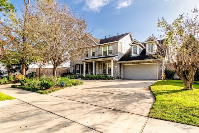 view of front of house featuring a front lawn, concrete driveway, fence, and an attached garage