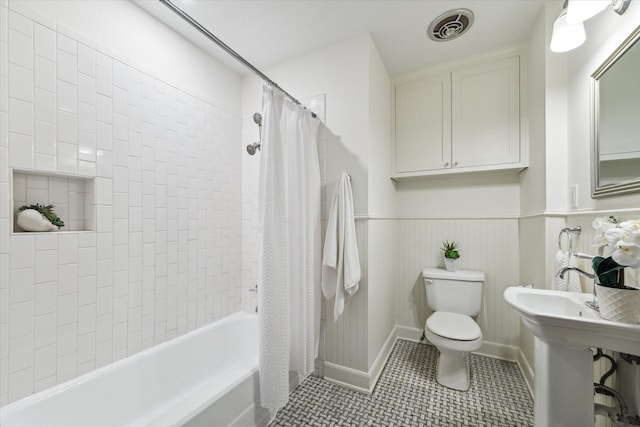 full bathroom featuring visible vents, toilet, shower / tub combo, wainscoting, and tile patterned flooring