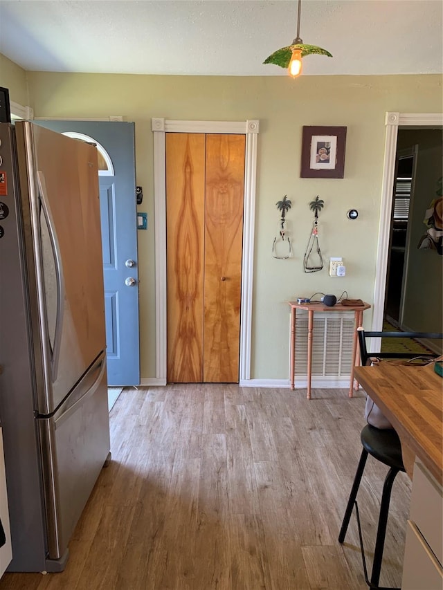 kitchen featuring freestanding refrigerator, baseboards, and wood finished floors