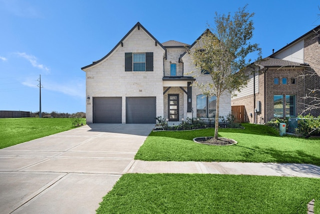 french country home with concrete driveway, a garage, stone siding, and a front lawn