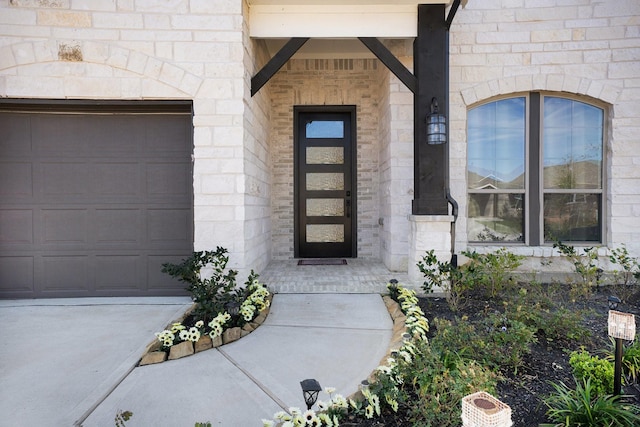 entrance to property with a garage and stone siding