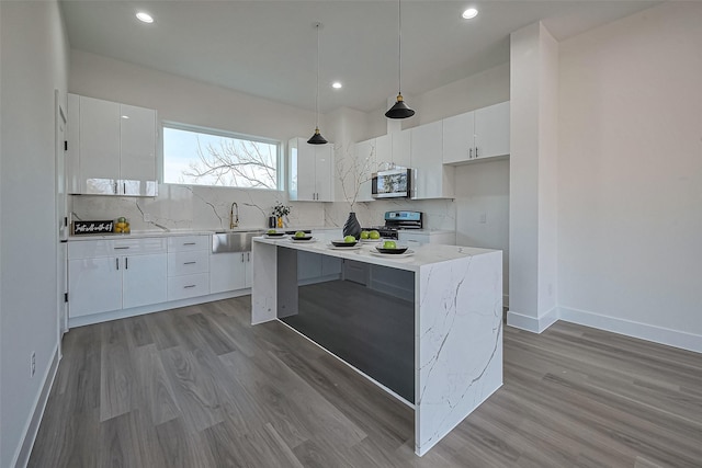 kitchen with white cabinetry, tasteful backsplash, appliances with stainless steel finishes, and a sink