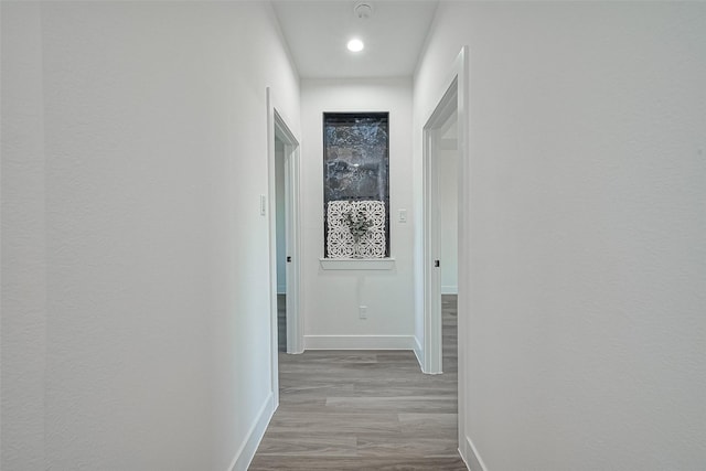 hall with wood finished floors and baseboards