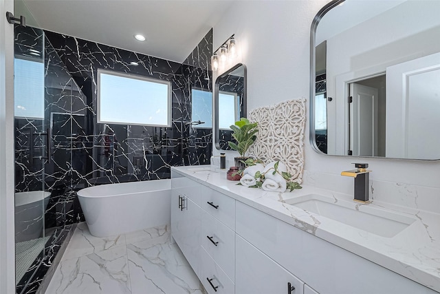 full bath with double vanity, a freestanding tub, recessed lighting, a sink, and marble finish floor