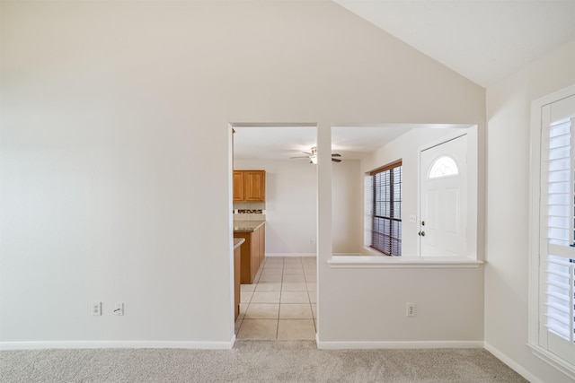 empty room with baseboards, lofted ceiling, light carpet, and ceiling fan