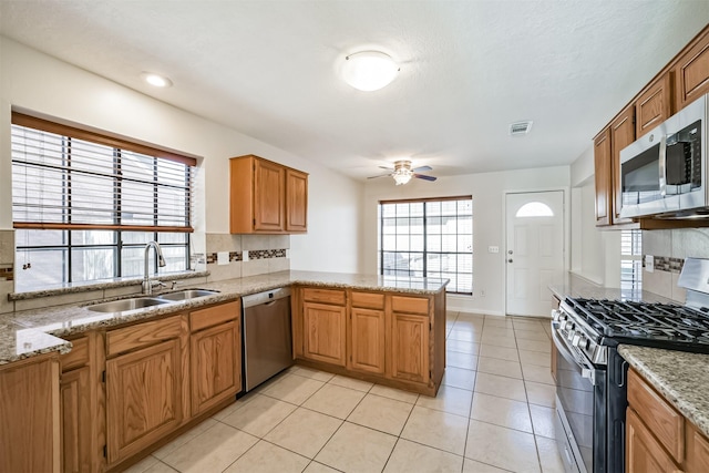 kitchen with a sink, stainless steel appliances, visible vents, and decorative backsplash