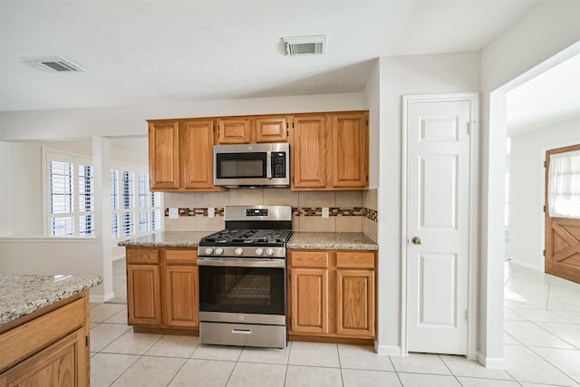 kitchen featuring light tile patterned floors, visible vents, appliances with stainless steel finishes, and decorative backsplash