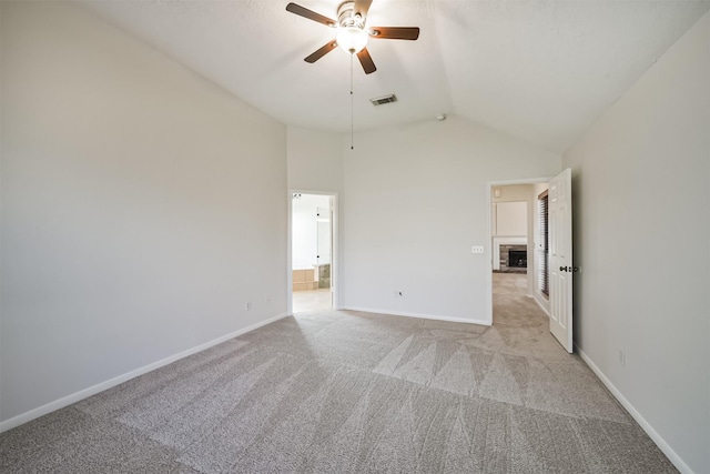 empty room featuring visible vents, baseboards, light colored carpet, ceiling fan, and vaulted ceiling