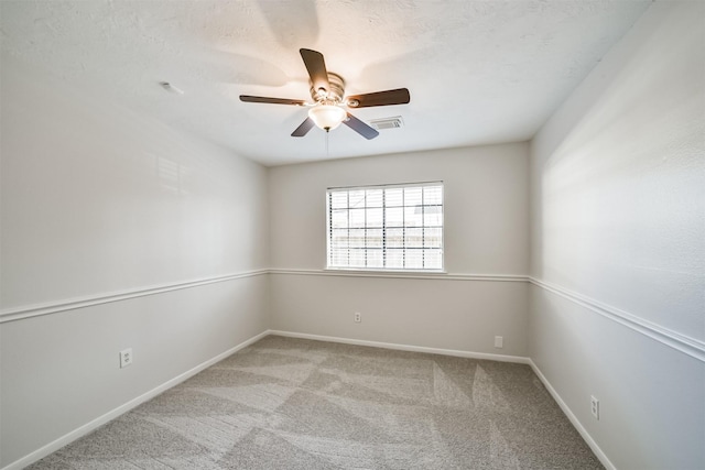 empty room featuring visible vents, ceiling fan, baseboards, carpet, and a textured ceiling