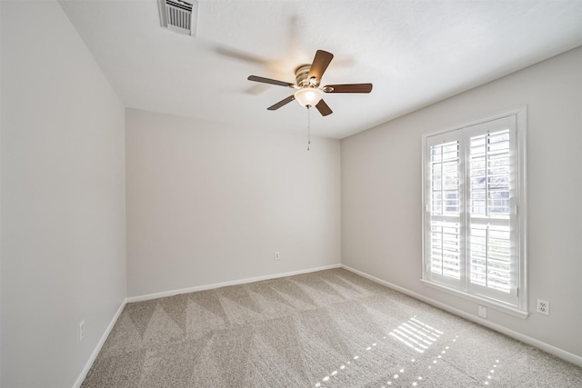 carpeted empty room featuring a wealth of natural light, visible vents, and baseboards