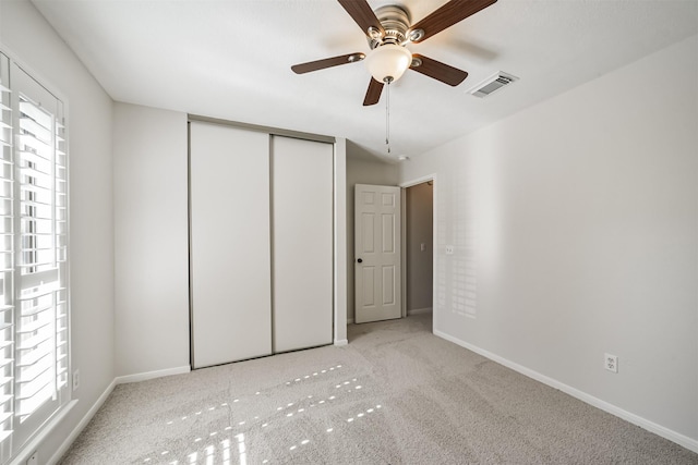 unfurnished bedroom with visible vents, ceiling fan, baseboards, carpet, and a closet