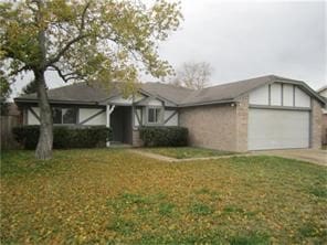 view of front of property with a front yard, concrete driveway, and an attached garage