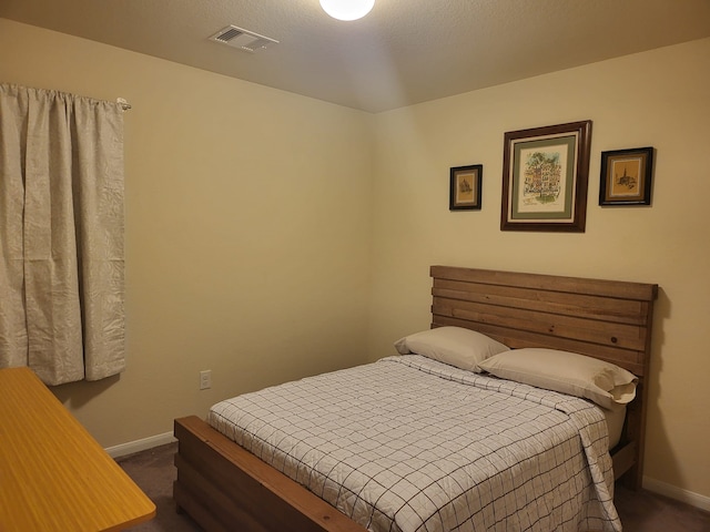 bedroom featuring visible vents, baseboards, and dark carpet