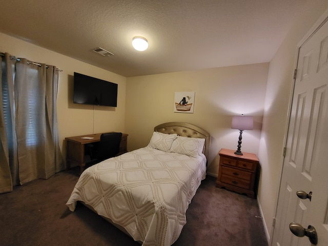 bedroom featuring carpet, visible vents, and a textured ceiling