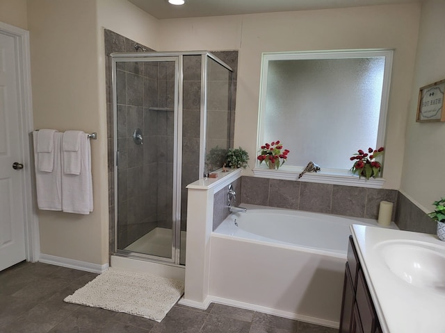 bathroom featuring baseboards, vanity, a bath, and a shower stall