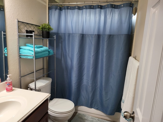 full bath featuring toilet, radiator, vanity, and a textured wall