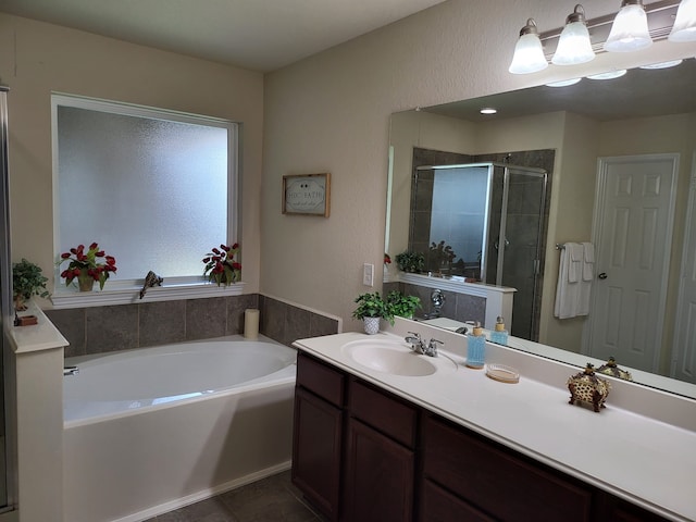 full bathroom with vanity, a garden tub, a shower stall, and tile patterned flooring