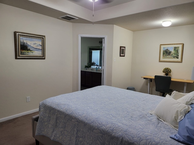 carpeted bedroom featuring ensuite bath, baseboards, and visible vents