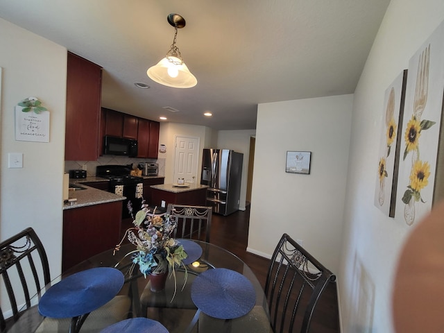 dining room featuring dark wood-style floors, visible vents, and baseboards