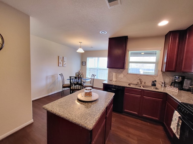 kitchen with visible vents, backsplash, dark wood-type flooring, black appliances, and a sink