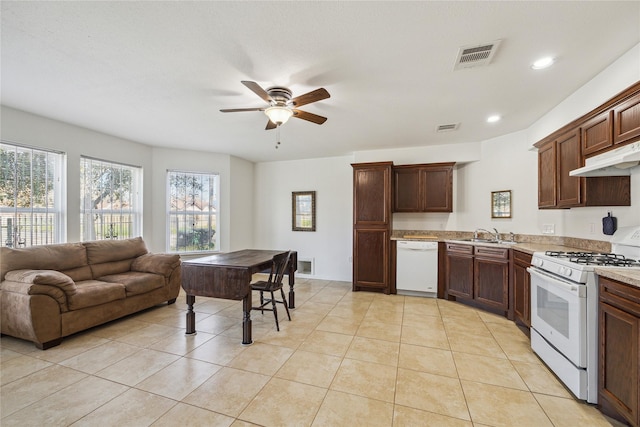 kitchen with under cabinet range hood, visible vents, white appliances, and light tile patterned floors