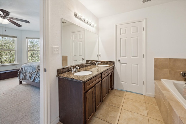 ensuite bathroom with a sink, tiled tub, ensuite bath, and tile patterned floors