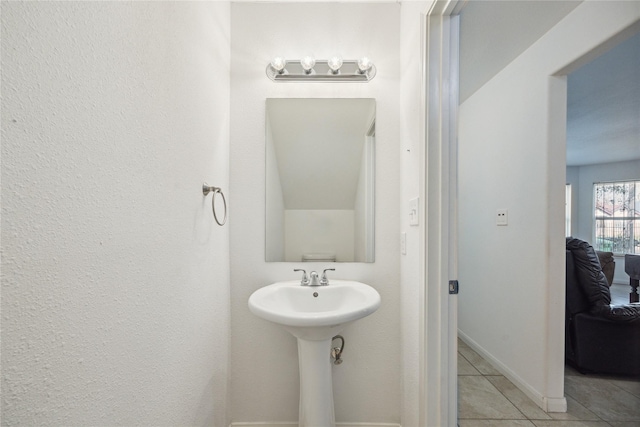 bathroom with baseboards and tile patterned flooring