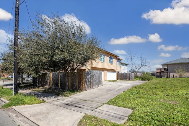 view of home's exterior with a garage, driveway, and fence