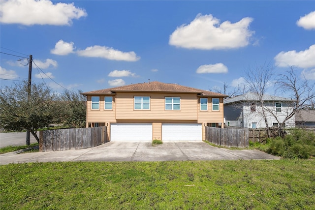 exterior space featuring fence, a garage, driveway, and a lawn