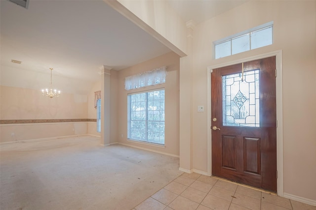 foyer with tile patterned floors, baseboards, carpet, and a chandelier